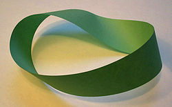 A Möbius strip made with a piece of paper and tape. If an ant were to crawl along the length of this strip, it would return to its starting point having traversed the entire length of the strip (on both sides of the original paper) without ever crossing an edge.